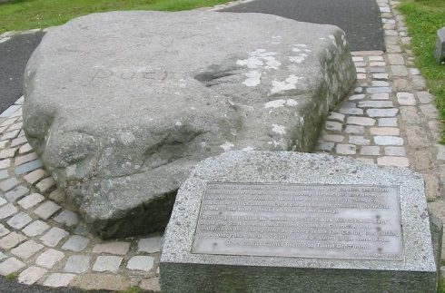 Reputed site of burial of Saint Patrick, in churchyard of Cathedral in Downpatrick, Northern Ireland. The plaque reads: “According to tradition the remains of St. Patrick with those of St. Brigid and St. Columba were reinterred on this site by John De Courcy in the 12th Century thus fulfilling the prophecy that the three Saints would be buried in the same place.”