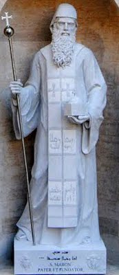 Sculpture of Saint Maron at the Saint Peter's Basilica in the Vatican. At his feet is an inscription in Syriac of the psalms that reads: The righteous will flourish like a palm tree, they will grow like a cedar of Lebanon. 