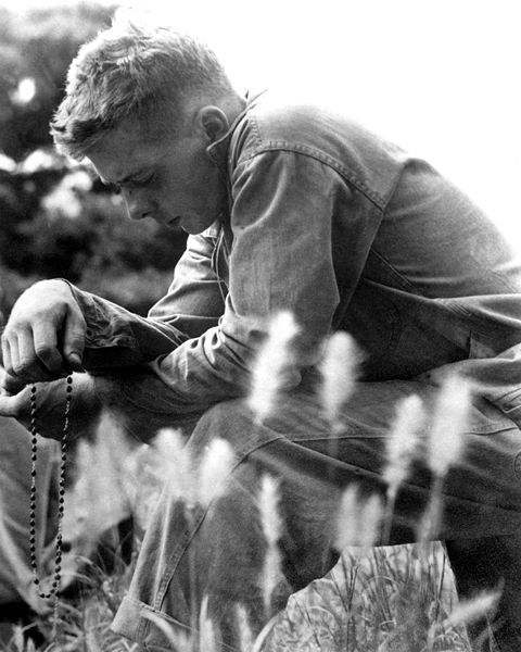 A Marine prays the Rosary during the Korean War. Minutes later, the 1st Marine Division launched an offensive against entrenched communist troops during the Korean conflict.