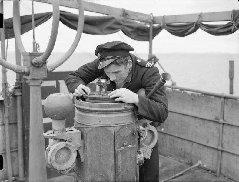 A Navy Sailor taking a compass reading whilst the ship was in convoy, during the Second World War.