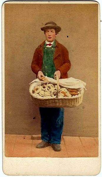 An Italian young street-vendor selling bagels.